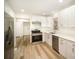 Modern kitchen features stainless appliances, white cabinetry, and wood-look flooring at 4921 Churchill Dr, Charlotte, NC 28269