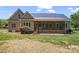 Home exterior featuring a screened porch and brick foundation on a sunny day at 520 Steeple Chase Trl, Salisbury, NC 28144