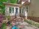 Home's back entrance features brick stairs, metal railing, and a vibrant blue door, nestled within a landscaped yard at 5935 Winburn Ln, Charlotte, NC 28226
