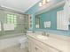 Bright blue bathroom with white vanity, large mirror, and tiled shower-tub combo at 5935 Winburn Ln, Charlotte, NC 28226