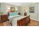 Cozy bedroom features a wood sleigh bed, neutral paint and a view to the en-suite bathroom at 5935 Winburn Ln, Charlotte, NC 28226