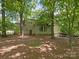 The exterior of the home is nestled among towering trees and features a sunroom and a partial view of the backyard at 5935 Winburn Ln, Charlotte, NC 28226