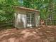 Outbuilding with double doors, nestled among mature trees on a pine-covered ground at 5935 Winburn Ln, Charlotte, NC 28226