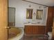 Bathroom featuring double sinks, a soaking tub, and wood cabinets, blending functionality with comfort at 6293 Karen Dr, Claremont, NC 28610