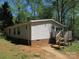 Rear view of a home with brick foundation, featuring a small porch and steps leading to the backyard at 6293 Karen Dr, Claremont, NC 28610