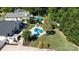 Aerial view of a backyard featuring a kidney shaped pool, patio, outdoor fireplace, and lush landscaping at 7018 Huntsmaster Dr, Charlotte, NC 28277