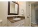 Bright bathroom featuring single granite vanity, framed mirror, and brushed fixtures at 7018 Huntsmaster Dr, Charlotte, NC 28277