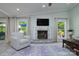Bright living room with fireplace, large windows, and view to the green backyard at 7018 Huntsmaster Dr, Charlotte, NC 28277