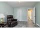 Relaxing living room with recliner, ceiling fan, and neutral colored walls at 7018 Huntsmaster Dr, Charlotte, NC 28277