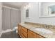 Bathroom featuring double vanity with granite countertops, tile floors, and updated lighting at 7607 Petrea Ln, Charlotte, NC 28227
