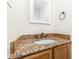 Bathroom vanity with granite countertop, bronze faucet, and a framed mirror on a light beige wall at 7607 Petrea Ln, Charlotte, NC 28227