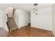 Living room featuring wood floors, staircase with carpet and pendant lights at 7607 Petrea Ln, Charlotte, NC 28227