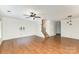 Spacious living room with wood floors, a ceiling fan and staircase leading to the upper level at 7607 Petrea Ln, Charlotte, NC 28227