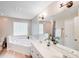 Bright bathroom features a double vanity sink and a tiled tub and shower at 812 Timber Creek Dr, York, SC 29745