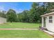 Expansive backyard with lush green grass, a brick pathway, and partial views of the home's exterior at 814 Columbia Dr, Chester, SC 29706