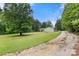 A gravel driveway leads to this beautiful home with an expansive front yard and mature trees at 814 Columbia Dr, Chester, SC 29706