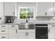 Farmhouse sink with white cabinets and stainless steel appliances under a large window at 814 Columbia Dr, Chester, SC 29706