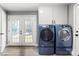 Laundry room featuring modern washer and dryer sets, white cabinets, and access to backyard at 814 Columbia Dr, Chester, SC 29706