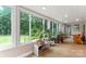 Bright sunroom with floor-to-ceiling windows and wood floors overlooks the lush yard at 814 Columbia Dr, Chester, SC 29706