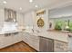 Updated kitchen with white cabinets, stainless steel appliances, marble countertops, and a farmhouse sink at 916 Cherokee Rd, Charlotte, NC 28207