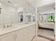 Main bathroom with double sinks, marble countertops, and a door leading into the bedroom at 916 Cherokee Rd, Charlotte, NC 28207
