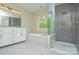 Luxurious bathroom with a soaking tub, tiled shower, double sink vanity and large window at 9713 Autumn Applause Dr, Charlotte, NC 28277