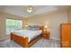 Cozy bedroom featuring a king-size bed, tray ceiling, and natural light from a large window at 9713 Autumn Applause Dr, Charlotte, NC 28277