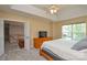 Bright bedroom with a ceiling fan, a large window, and carpeted floors, adjacent to an open loft space at 9713 Autumn Applause Dr, Charlotte, NC 28277
