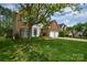 Traditional two-story home with brick accents, lush lawn, mature trees, and a two car garage at 9713 Autumn Applause Dr, Charlotte, NC 28277