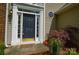 Close-up of a front door with sidelights, stylish hardware, and tasteful landscaping at 9713 Autumn Applause Dr, Charlotte, NC 28277