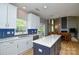 Open concept kitchen with a center island, white cabinets, and stainless steel appliances at 9713 Autumn Applause Dr, Charlotte, NC 28277