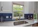 Bright kitchen features blue backsplash, stainless steel sink, and a window view to the backyard at 9713 Autumn Applause Dr, Charlotte, NC 28277