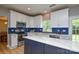 Modern kitchen featuring white cabinets, stainless steel appliances, and a stylish island with a white countertop at 9713 Autumn Applause Dr, Charlotte, NC 28277