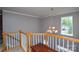 View of the second-floor landing, featuring a modern light fixture and lots of natural light at 9713 Autumn Applause Dr, Charlotte, NC 28277