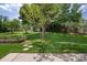 Lush backyard featuring a mature tree and a stone pathway leading to a garden at 1002 Banaba Dr, Indian Trail, NC 28079