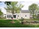 Spacious backyard with a well-maintained lawn, garden beds, patio, and mature trees at 1002 Banaba Dr, Indian Trail, NC 28079