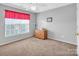 Relaxing bedroom featuring a bright window, soft carpet, and a charming wooden dresser and wall decor at 1002 Banaba Dr, Indian Trail, NC 28079