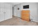 Neutral bedroom offers a wooden dresser, wall-mounted television and two bright white closets and light-colored carpet at 1002 Banaba Dr, Indian Trail, NC 28079
