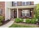 Inviting front porch with cozy seating, decorative plants, and a welcoming entrance with sidelight windows at 1002 Banaba Dr, Indian Trail, NC 28079