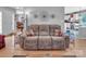 Inviting living room featuring a comfortable reclining sofa, hardwood floors, and modern decor at 1002 Banaba Dr, Indian Trail, NC 28079