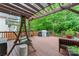 The inviting back deck features a charming swing, grill, and ample seating area perfect for outdoor enjoyment at 1009 Anduin Falls Dr, Charlotte, NC 28269