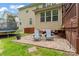 The backyard features a stone patio with Adirondack chairs, adjacent to the lush lawn and garden at 1009 Anduin Falls Dr, Charlotte, NC 28269