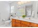 Bathroom featuring double sinks, a large mirror and vanity lighting, a toilet and shower with tub at 1009 Anduin Falls Dr, Charlotte, NC 28269