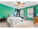 Bedroom featuring a bed, large windows, and blue-green color scheme, perfect for resting or studying at 1009 Anduin Falls Dr, Charlotte, NC 28269