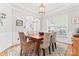Elegant dining room with a chandelier, decorative rug, and wainscoting, perfect for entertaining guests at 1009 Anduin Falls Dr, Charlotte, NC 28269