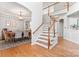 Open-concept foyer featuring wood floors, a staircase, and views into the dining room, creating an inviting atmosphere at 1009 Anduin Falls Dr, Charlotte, NC 28269
