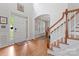 Grand foyer with hardwood floors, staircase, soaring ceilings, and abundant natural light streaming through the windows at 1009 Anduin Falls Dr, Charlotte, NC 28269