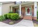 Inviting front entrance with a red door, brick steps, manicured shrubs, and decorative iron railings at 1009 Anduin Falls Dr, Charlotte, NC 28269