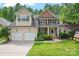 Charming two-story home featuring a two-car garage, brick accents, and manicured landscaping on a sunny day at 1009 Anduin Falls Dr, Charlotte, NC 28269