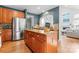 Well-equipped kitchen featuring a stainless steel refrigerator and center island with wood cabinets and granite counters at 1009 Anduin Falls Dr, Charlotte, NC 28269